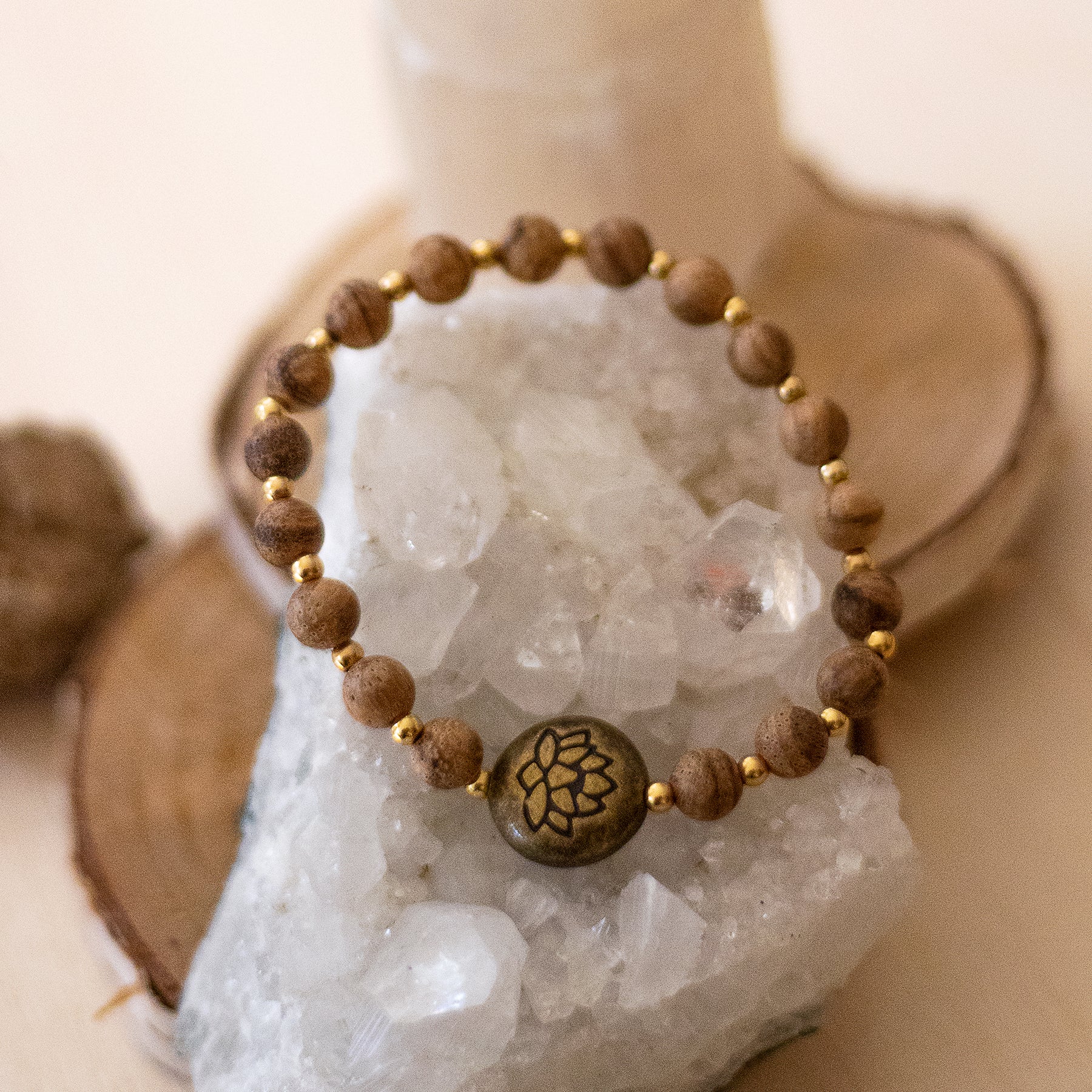 Bracciale loto legno naturale con perline dorate e simbolo della loto al centro