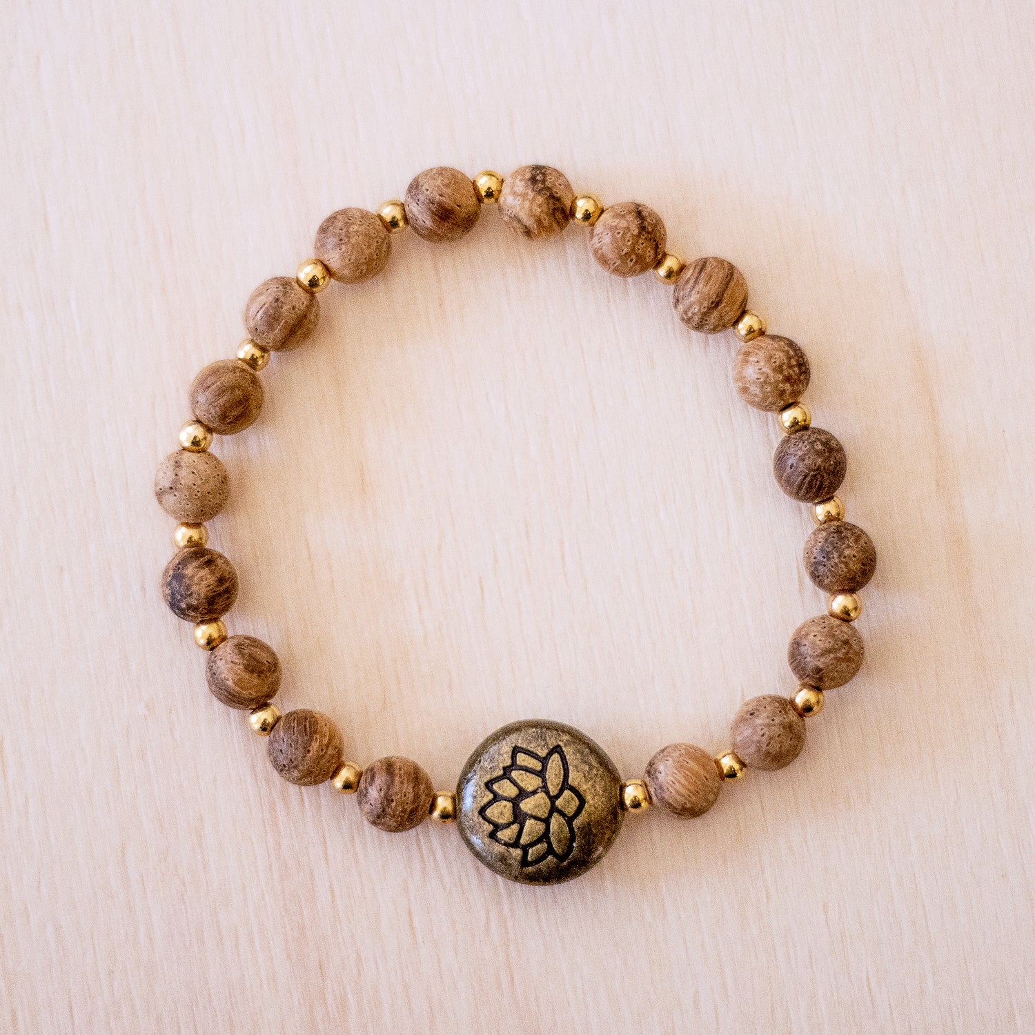 Bracciale loto legno naturale con perline dorate e simbolo di loto centrale per uno stile unico