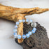 Bracciale loto opalite con perle azzurre e charm in metallo a forma di loto