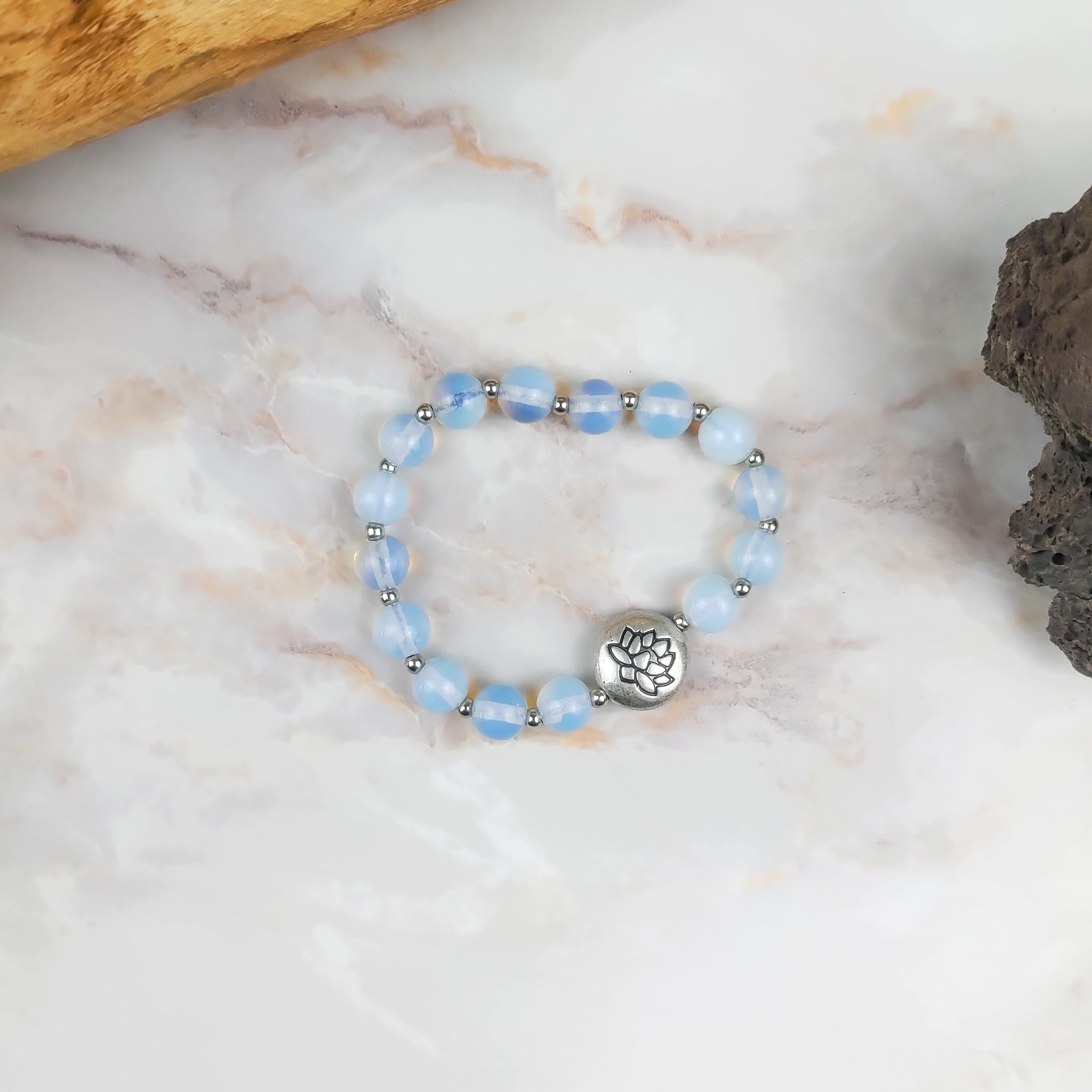 Bracciale loto opalite con perline azzurre e ciondolo in argento a forma di loto