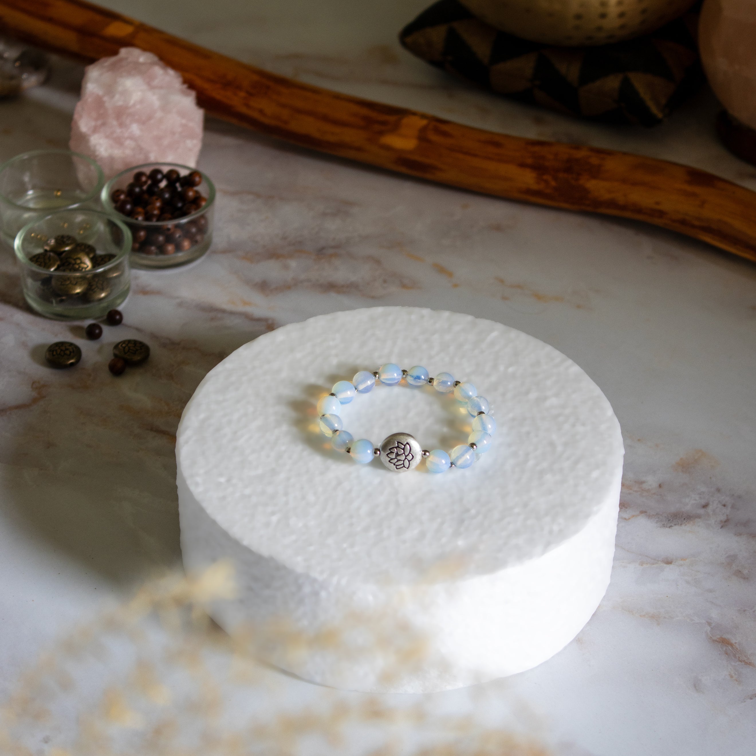 Bracciale loto opalite con perle blue e ciondolo con simbolo della vita in un ambiente zen