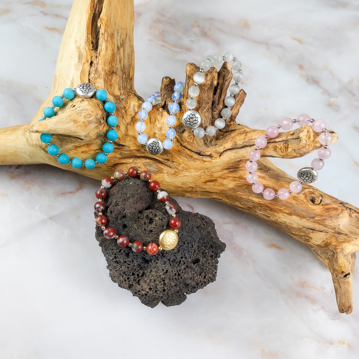 Collezione di bracciali con pietre preziose tra cui il bracciale loto rosso in evidenza