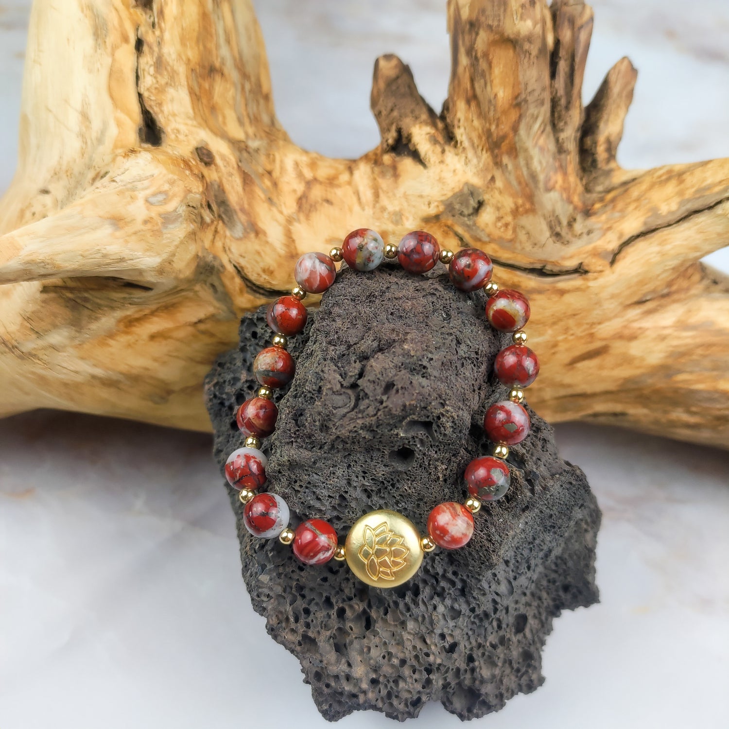 Bracciale loto rosso con perle di pietra e chiusura in oro, un accessorio elegante e spirituale