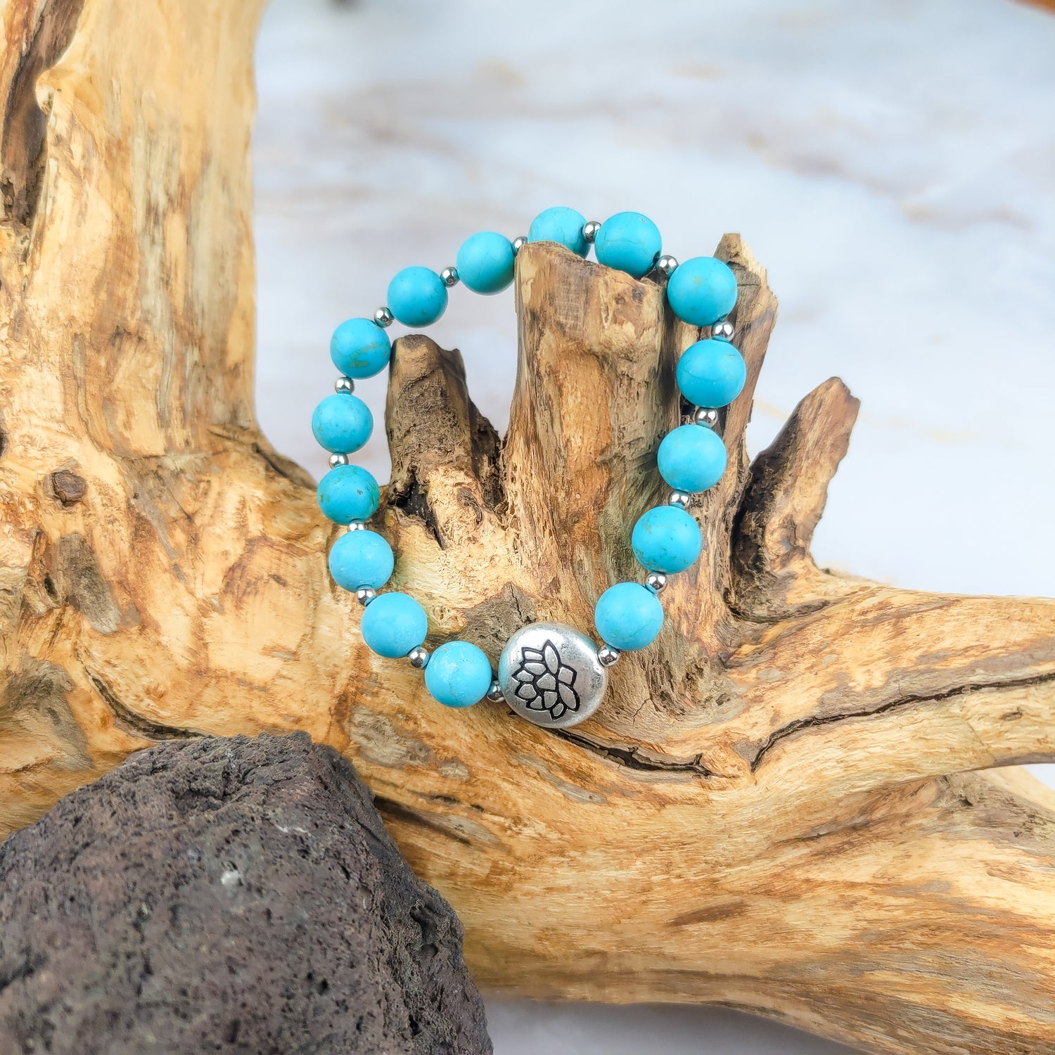 Bracciale loto turchese con perle azzurre e charm in metallo, elegante e spirituale