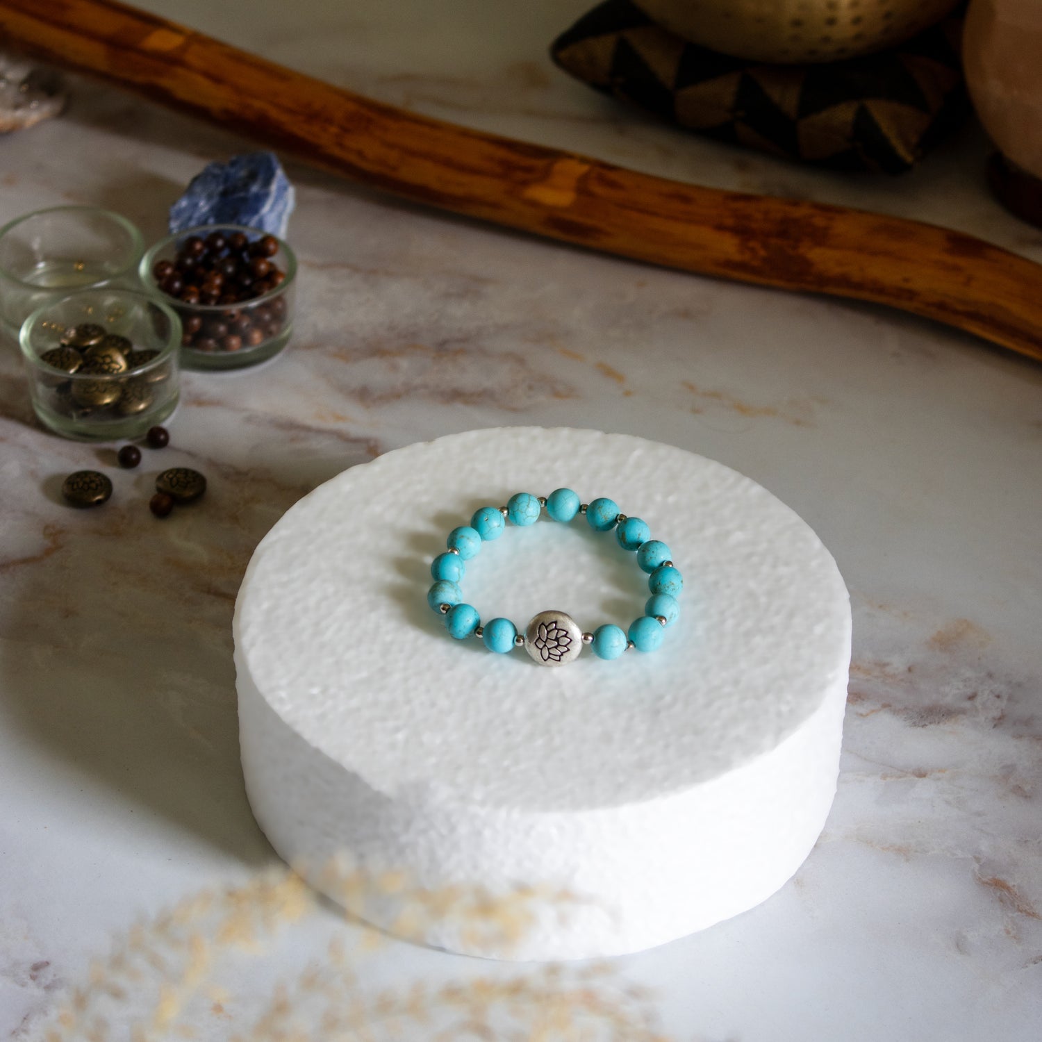 Bracciale loto turchese con perle colorate su un supporto bianco elegante