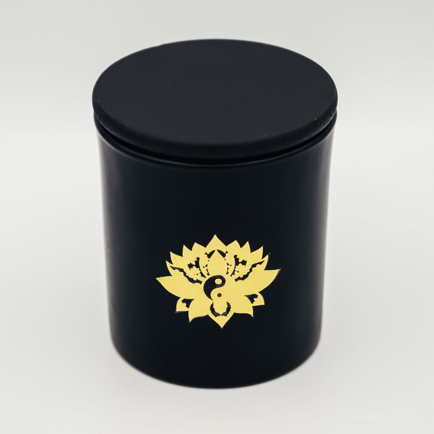Candela con cristalli in contenitore nero con logo di loto dorato di Shop Zen