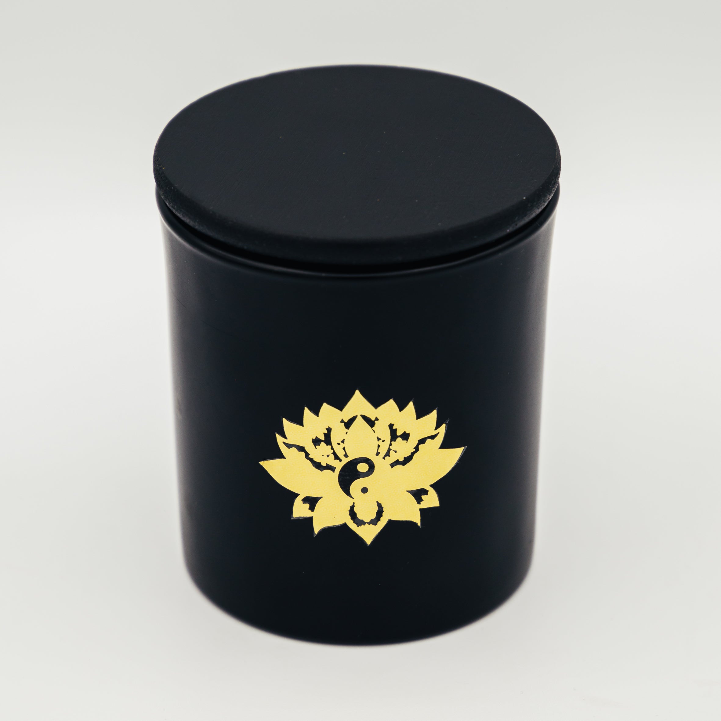 Candela con cristalli in contenitore nero con logo di loto dorato di Shop Zen