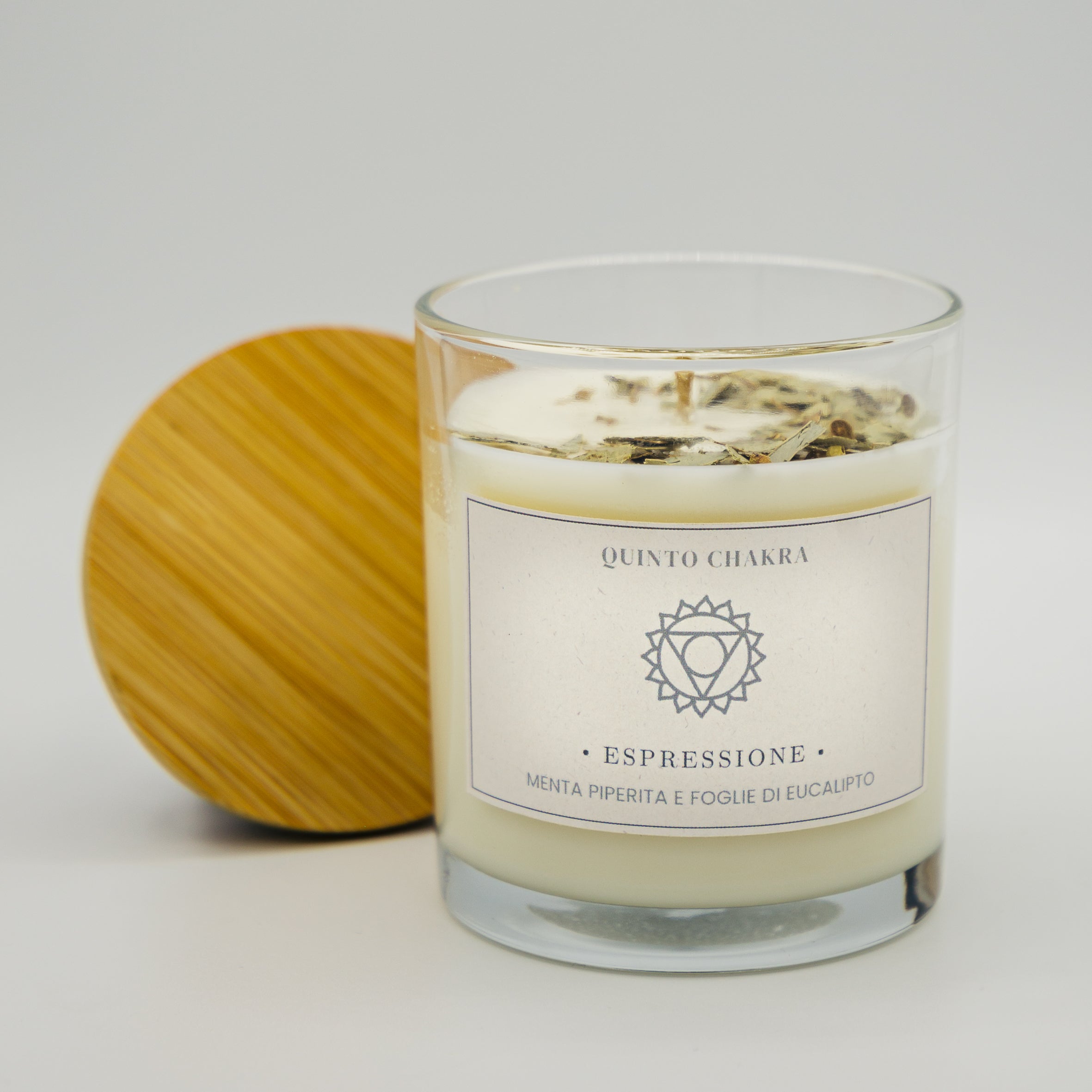 Candela espressione quinto chakra con menta piperita e foglie di eucalipto in contenitore trasparente