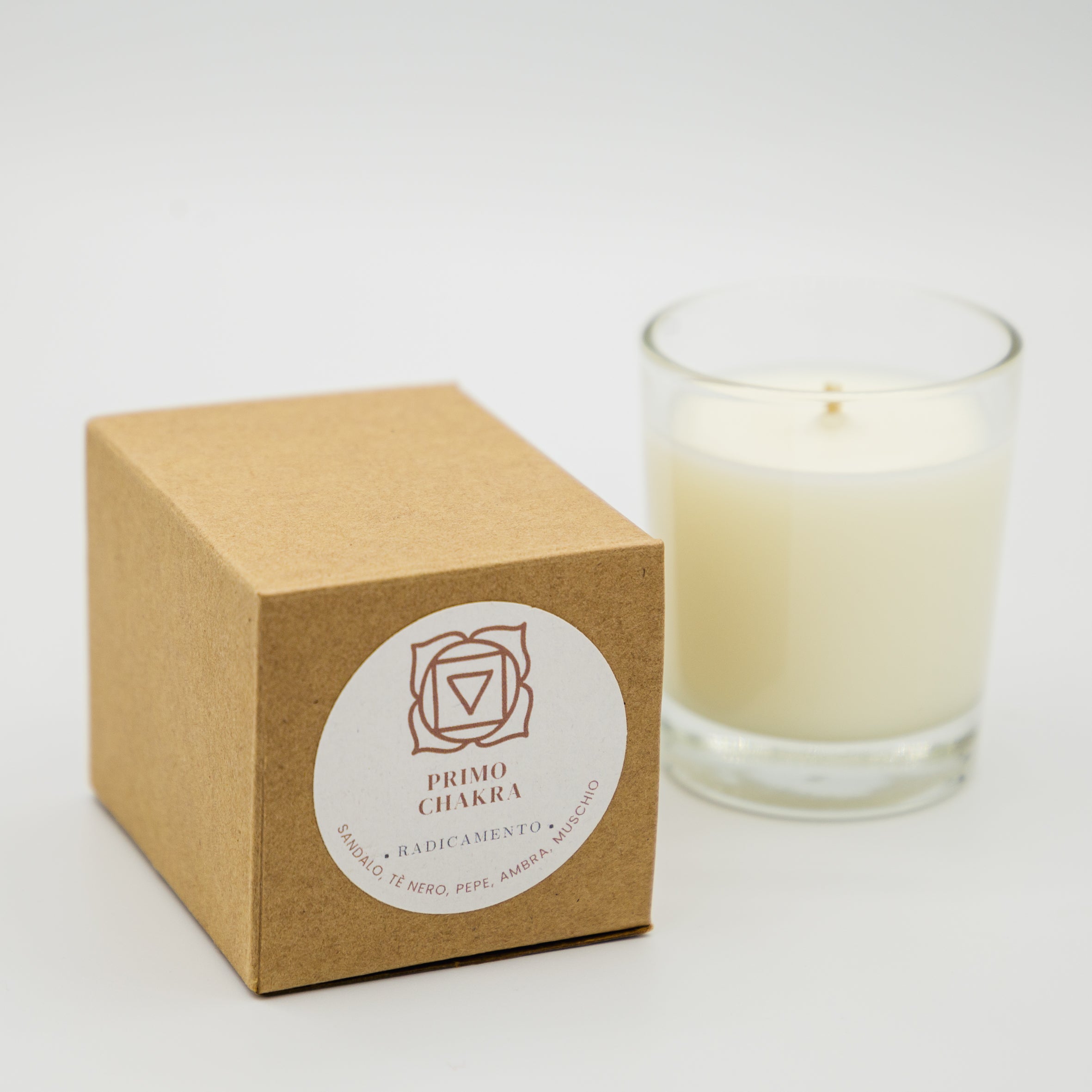 Candela radicamento primo chakra in confezione eco-friendly con profumo di erbe e legni