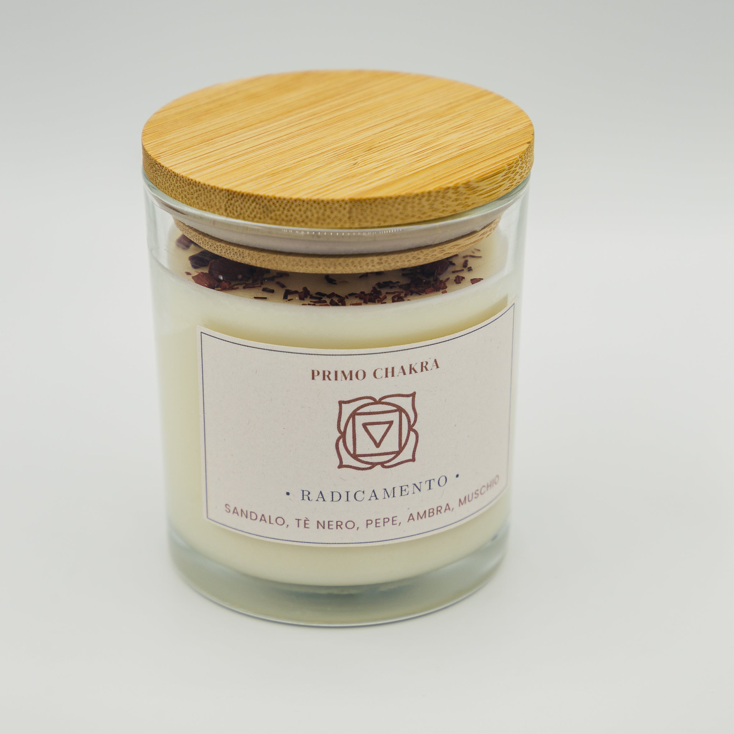 Candela radicamento primo chakra con ingredienti di sandalo, tè nero, pepe e ambra in vaso di vetro