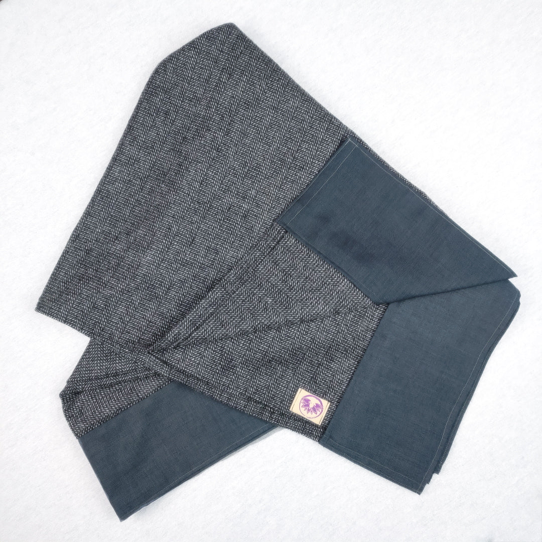 Coperta yoga effetto spigato in tonalità grigia, ideale per pratiche di meditazione e rilassamento.