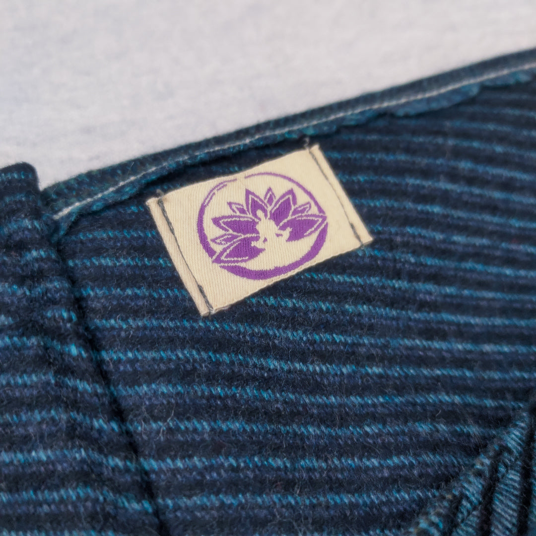 Etichetta di una coperta yoga lana shetland e alpaca con un design floreale distintivo