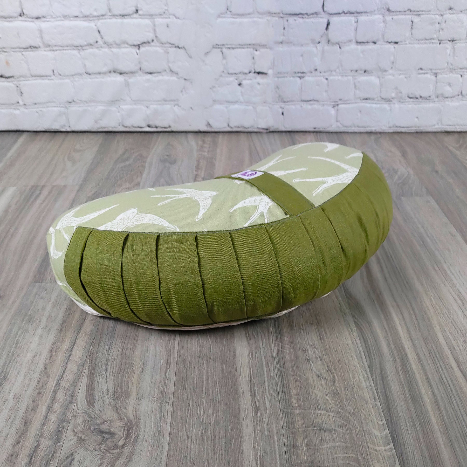 Cuscino zafu a mezzaluna rondini in tessuto verde, ideale per supporto lombare e comfort durante lo yoga