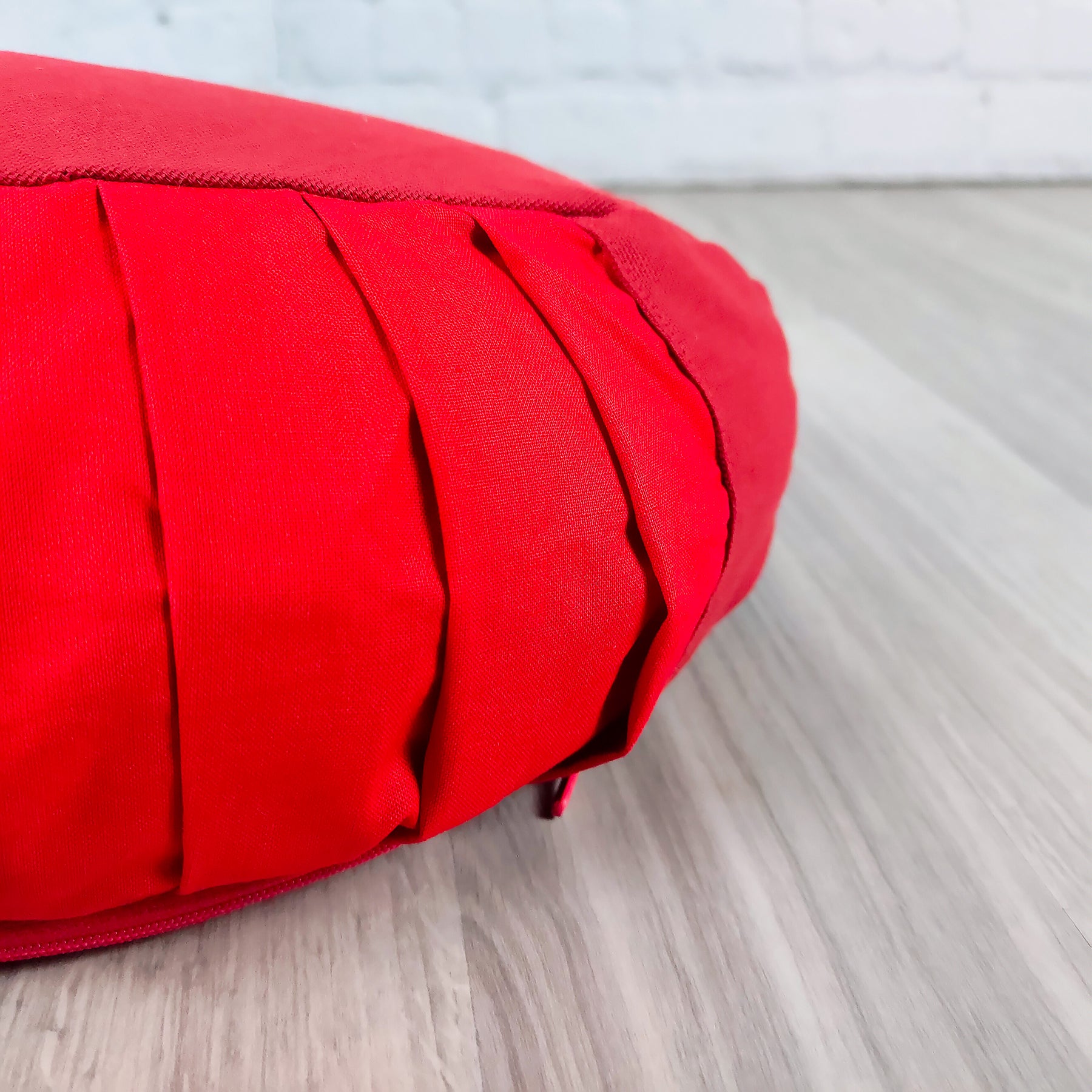 Cuscino Zafu a Mezzaluna rosso con pieghe decorative ideale per la postura e il comfort della schiena