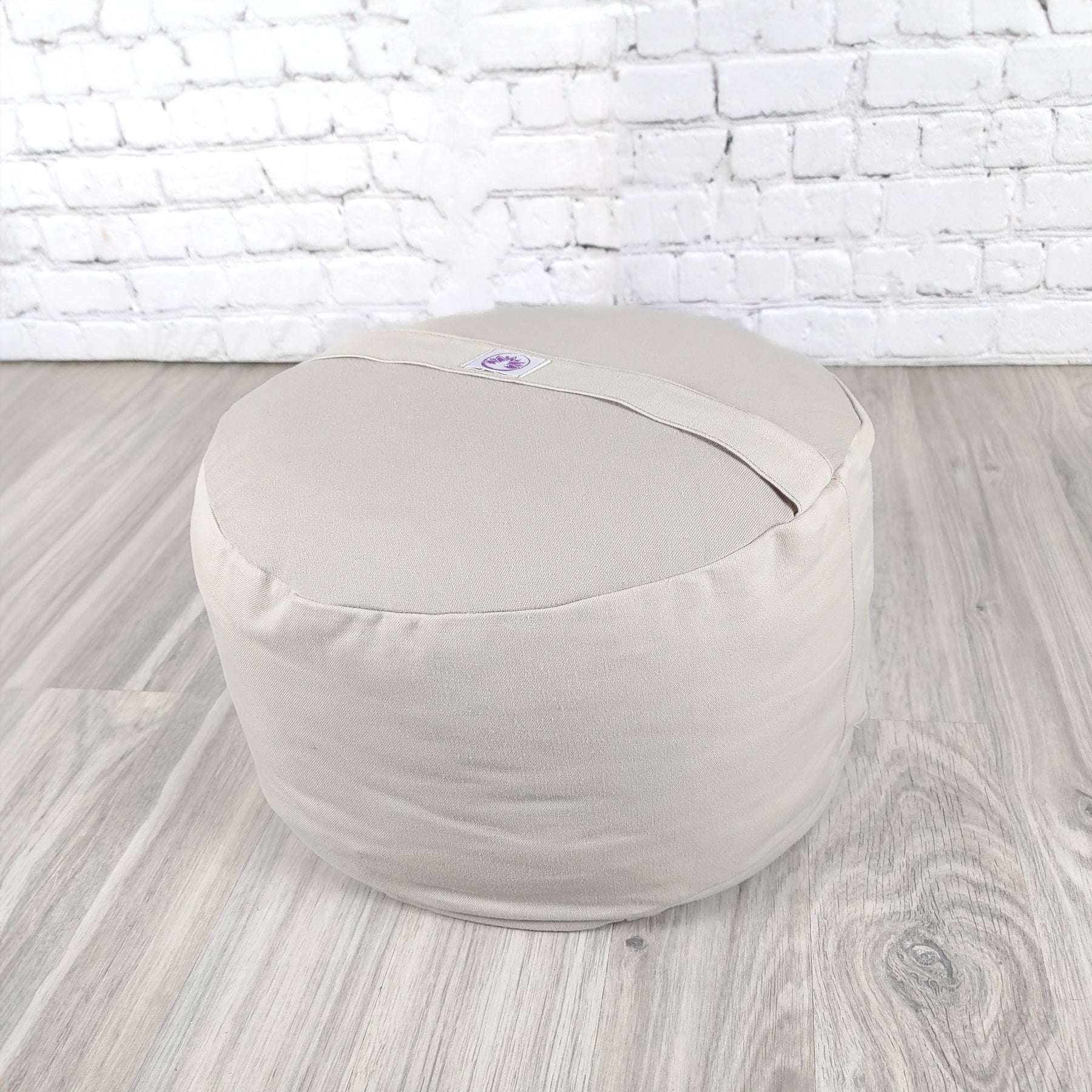 Cuscino zafu a ruota beige di Shop Zen, perfetto per supporto lombare e relax.