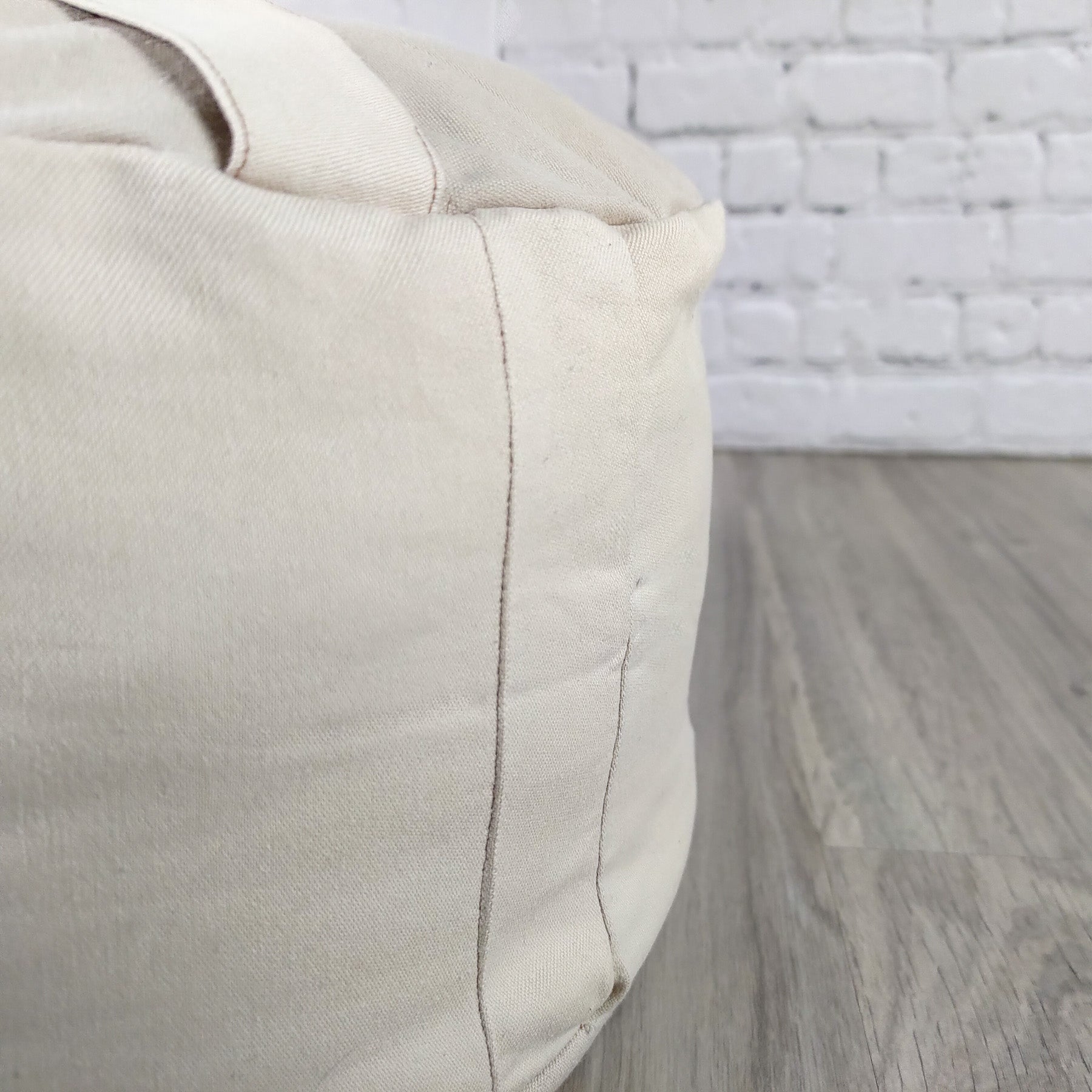 Cuscino zafu a ruota beige per supporto lombare e comfort durante la meditazione