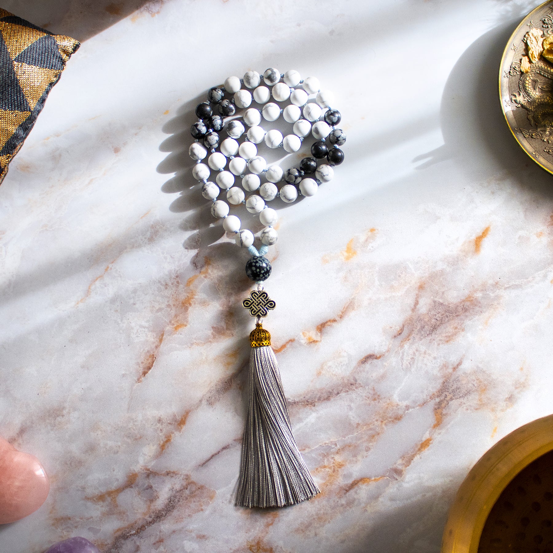 Collana mala ossidiana fiocco di neve con perle bianche e nere, tassello in tessuto e frangia decorativa