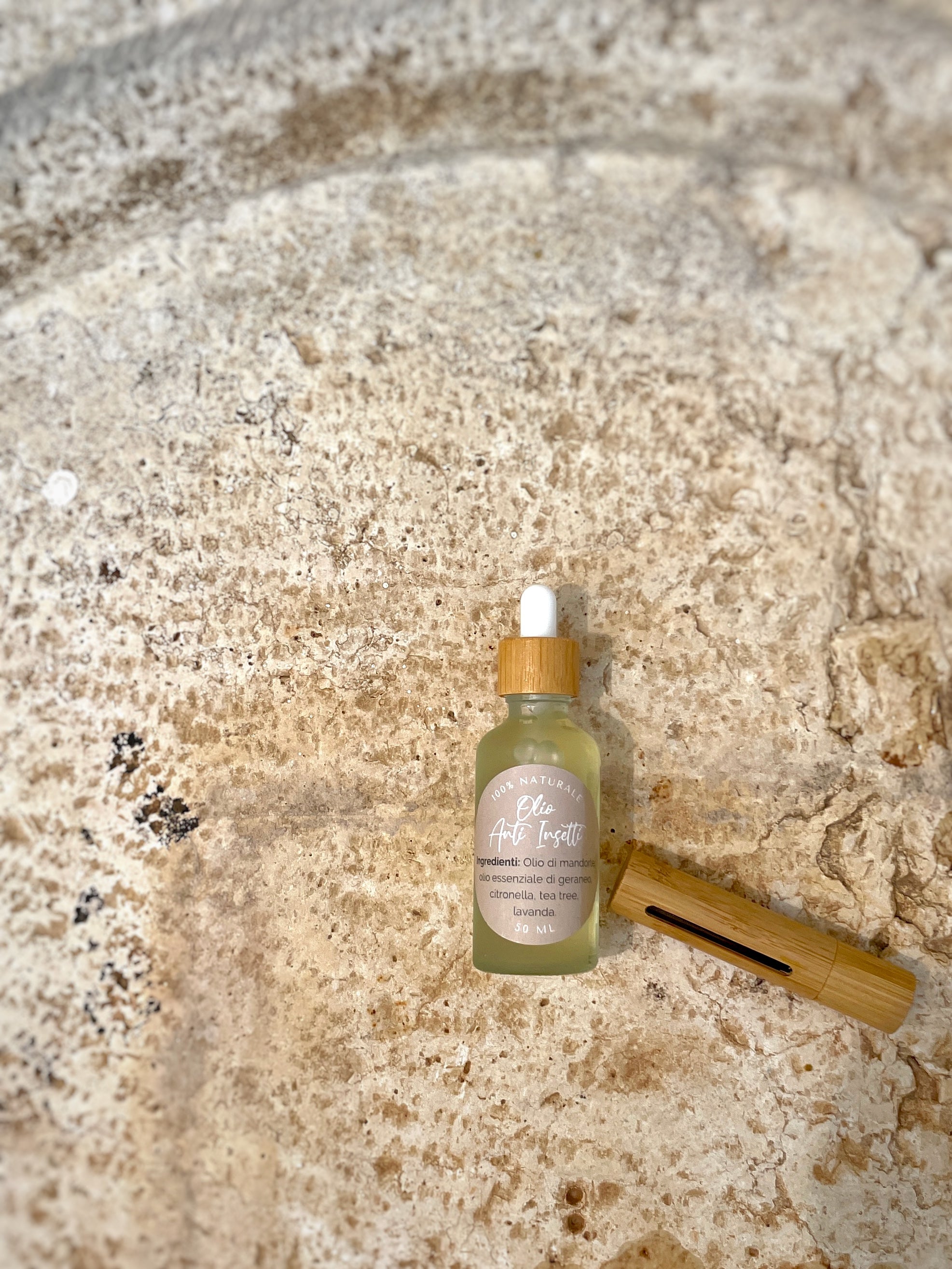 Olio naturale anti insetti di Shop Zen in bottiglia di vetro con contagocce su sfondo naturale
