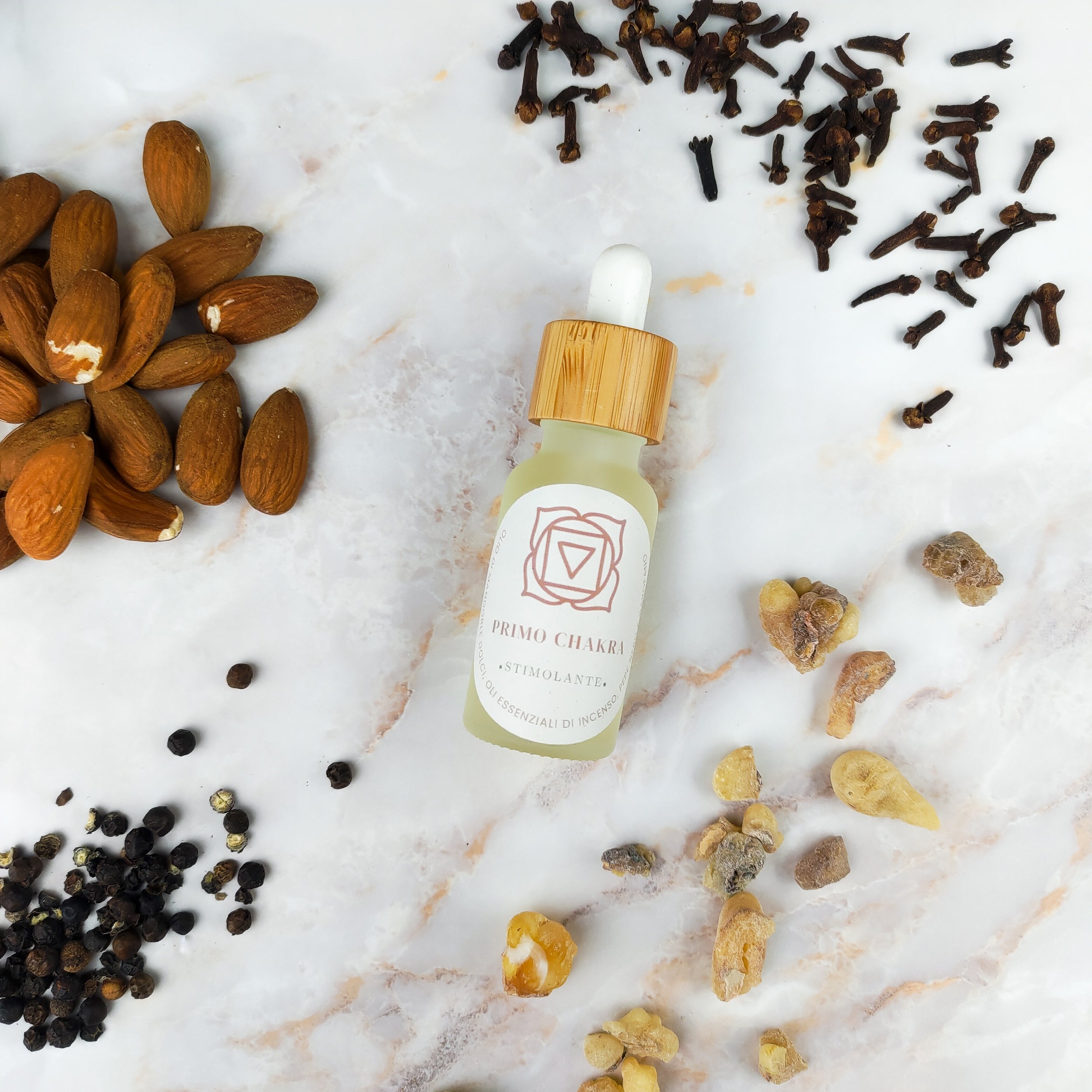 Olio per massaggi primo chakra con ingredienti naturali su superficie marmorea