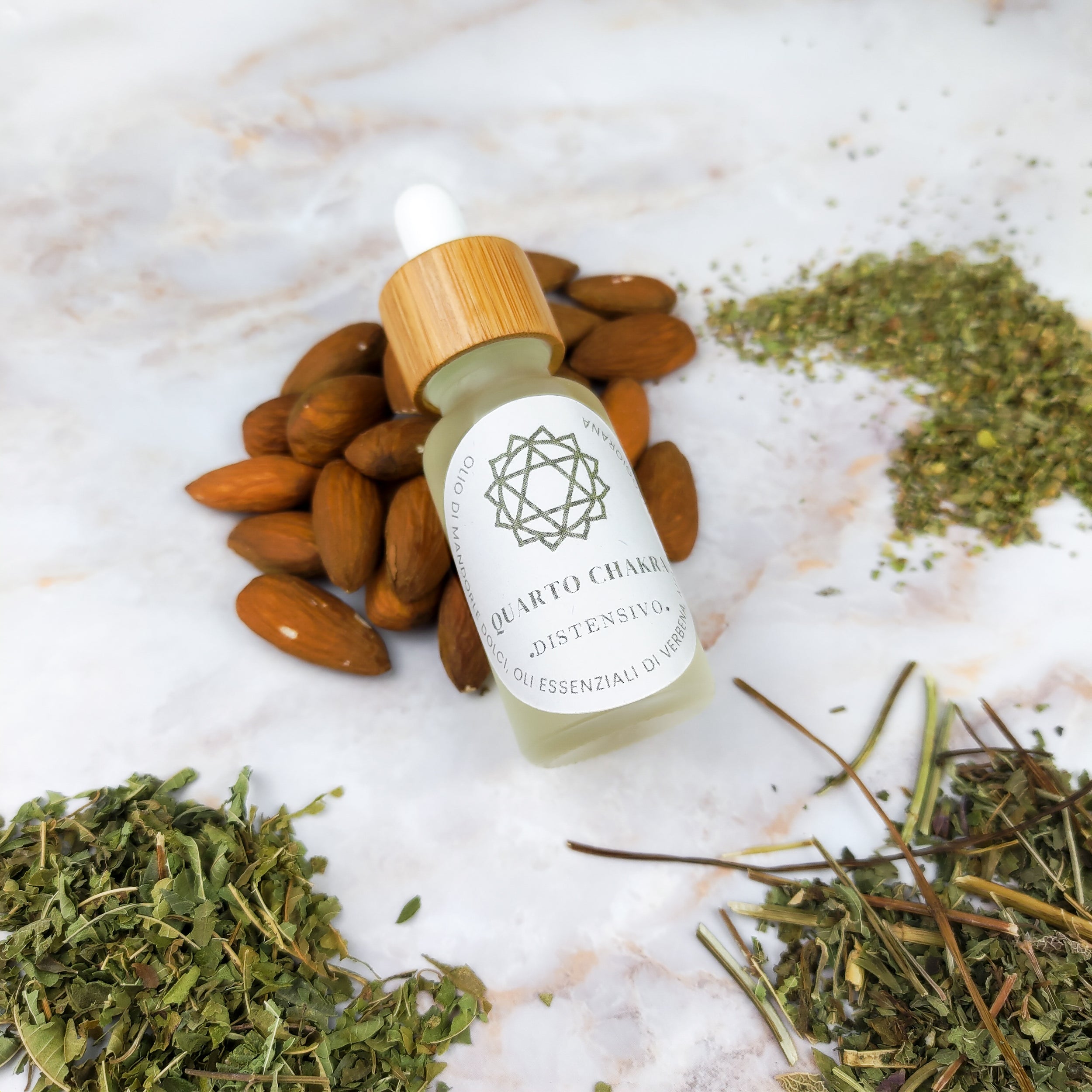 Olio per massaggi quarto chakra in flacone con pipetta, con mandorle e erbe essiccate in sfondo
