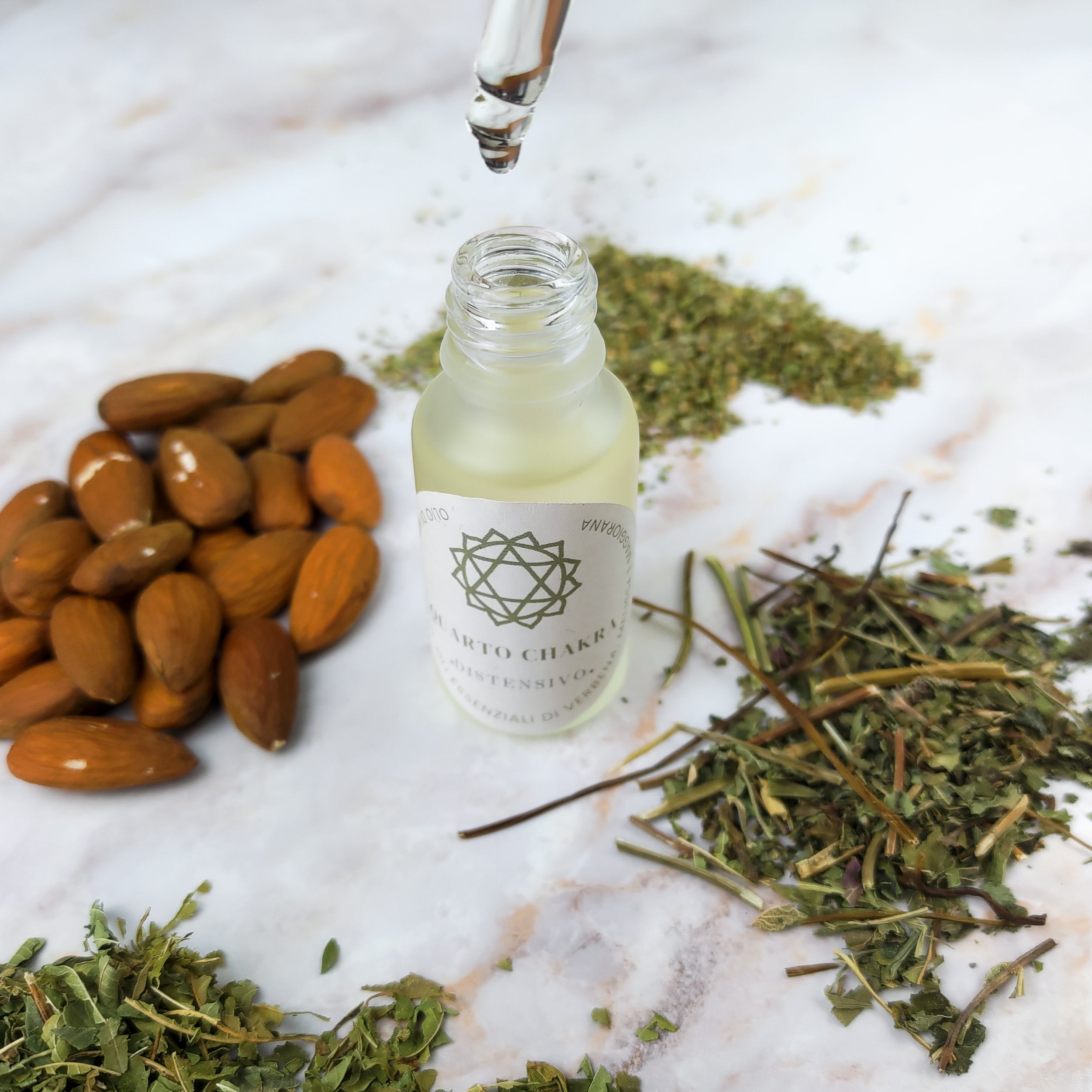 Olio per massaggi quarto chakra con ingredienti naturali e erbe su sfondo chiaro