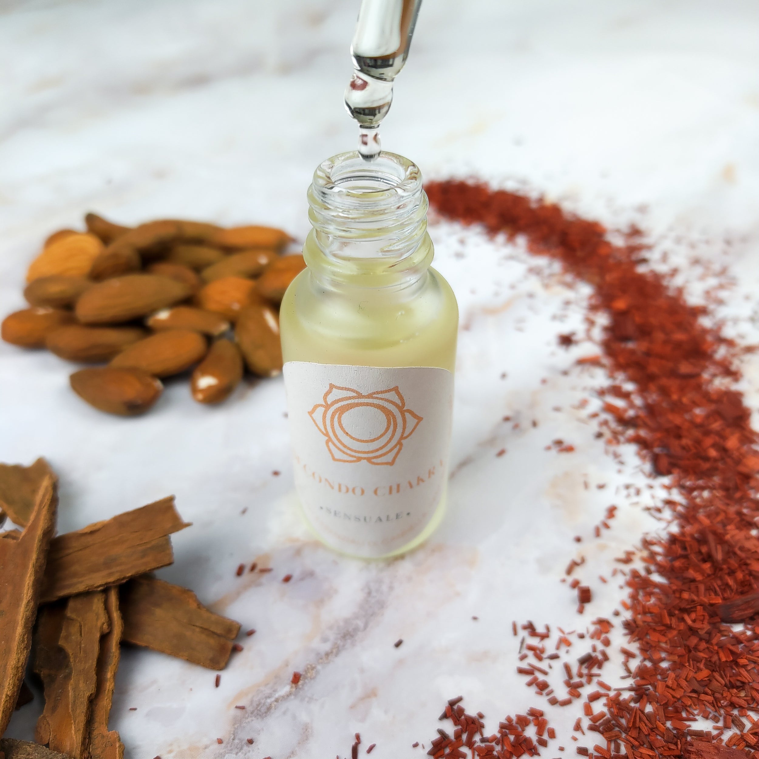 Olio per massaggi secondo chakra con estratti naturali su un sfondo di spezie e mandorle