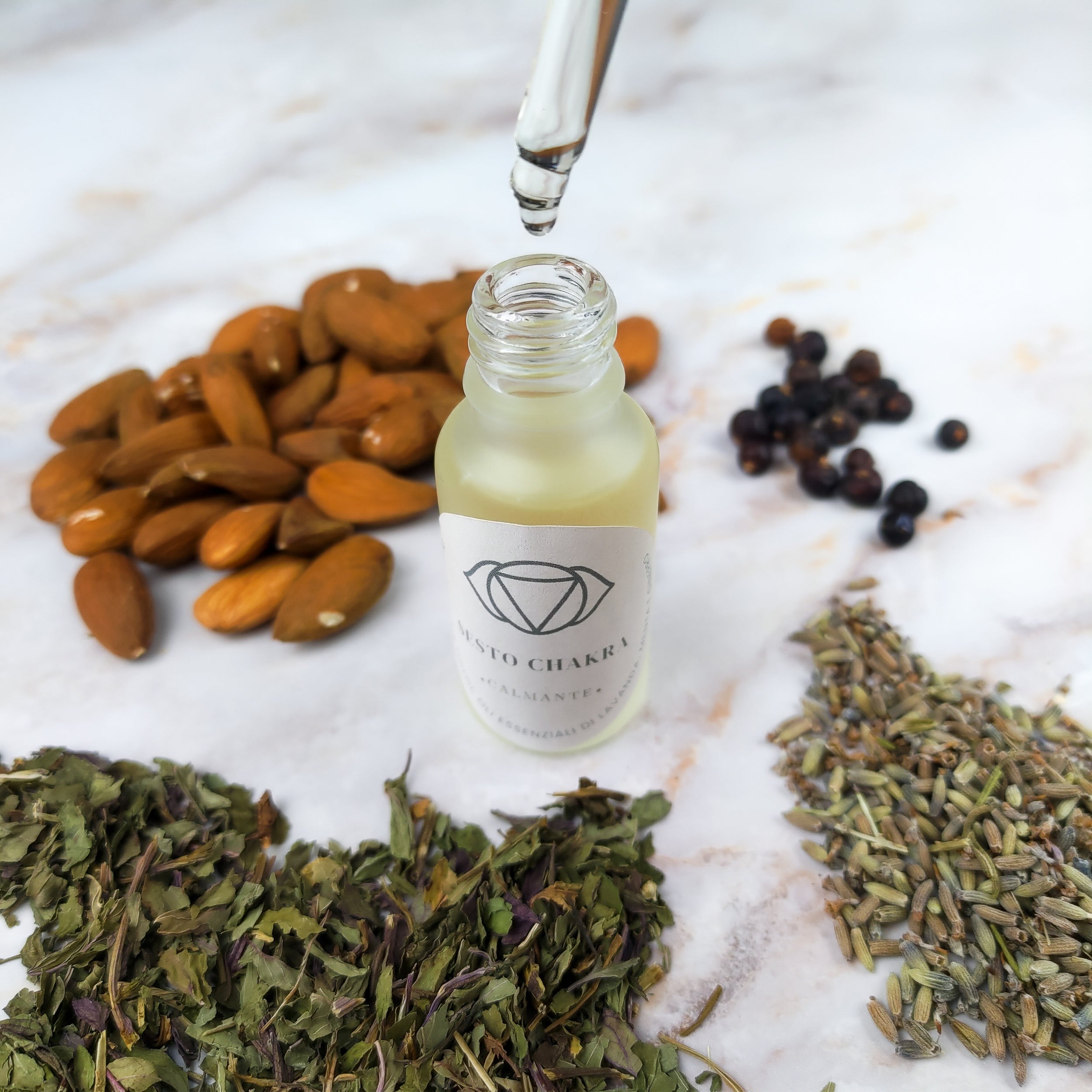Olio per massaggi sesto chakra in bottiglia con ingredienti naturali come mandorle e piante aromatiche