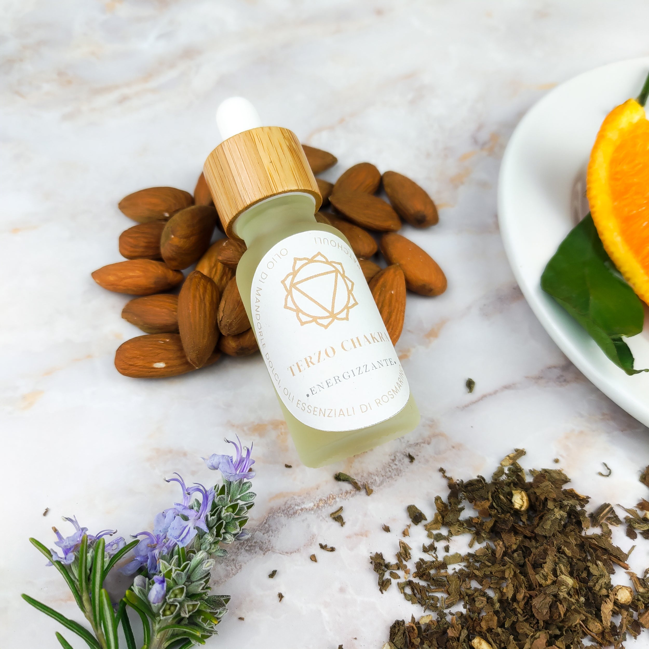 Olio per massaggi terzo chakra in bottiglia con tappo in legno, accanto a mandorle e piante aromatiche