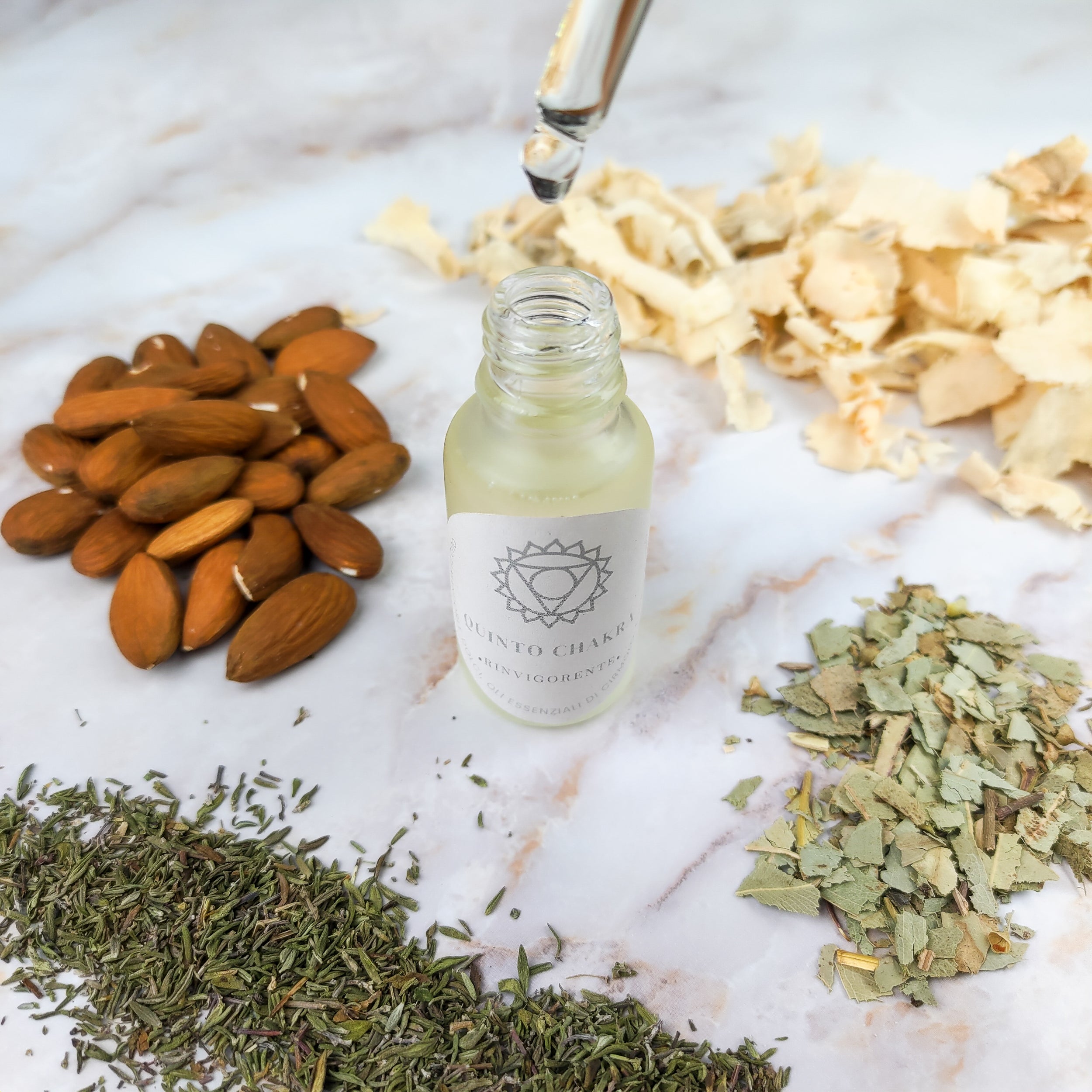 Flacone di olio per massaggi quinto chakra con ingredienti naturali come mandorle e erbe aromatiche
