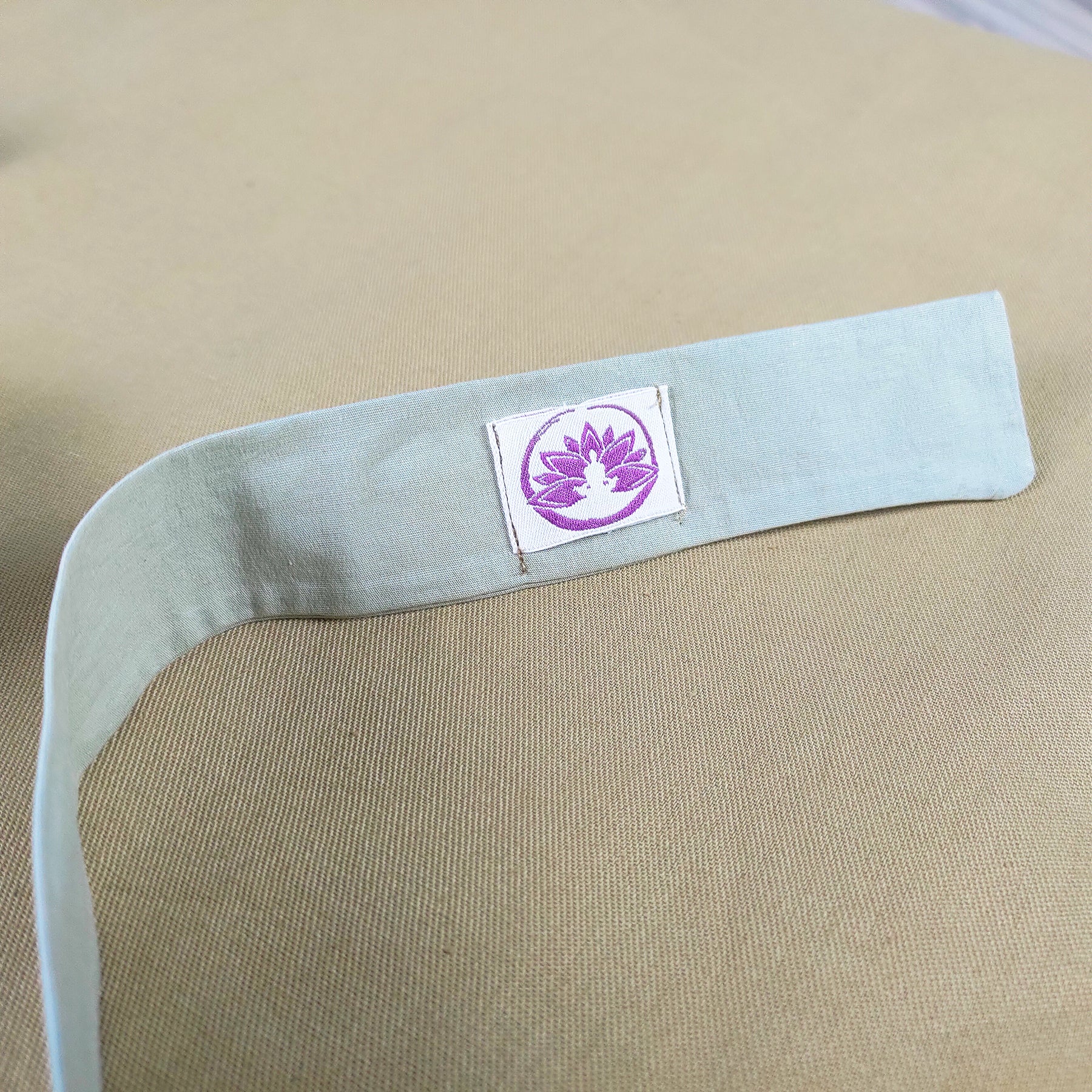 Dettaglio del tappetino zabuton naturale chiaro con etichetta per un comfort ottimale durante la meditazione