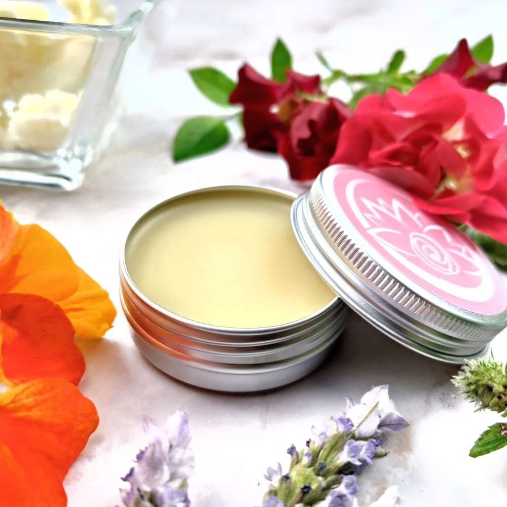 Burro corpo naturale aromatico in scatola metallica con fiori colorati intorno