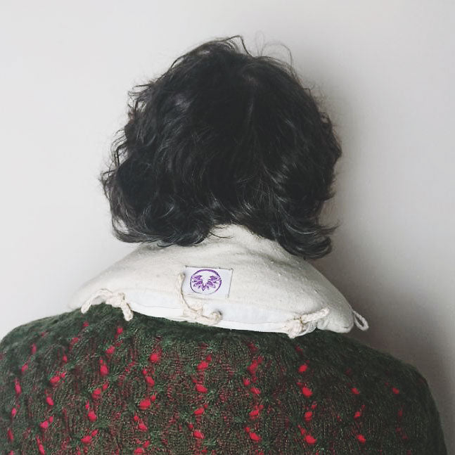 Cuscino defaticante naturale posizionato sul collo di una persona per sollievo e comodità