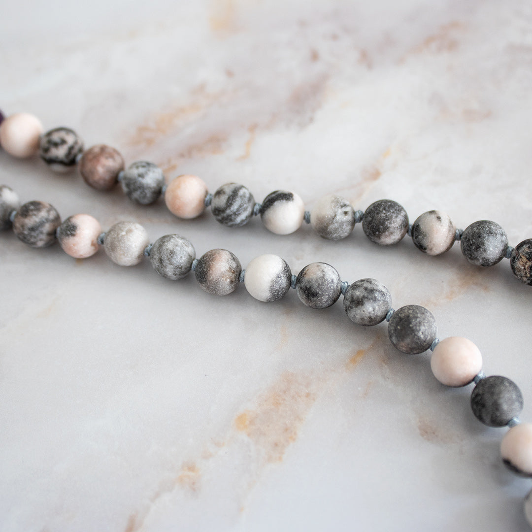 Collana mala ciaroite con perle colorate in sfumature di grigio e rosa per un look elegante