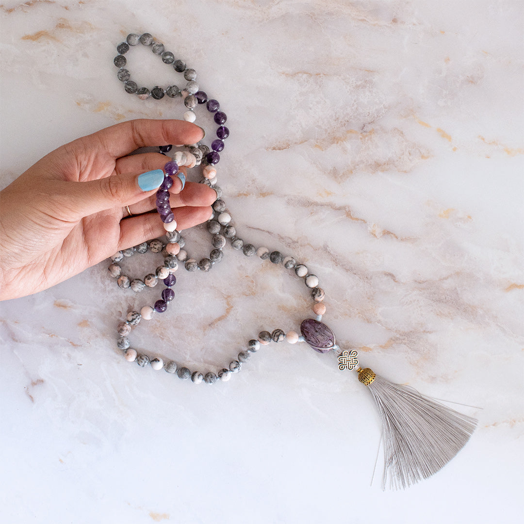 Collana mala ciaroite con perline grigie e viola, adornata con una frangia decorativa