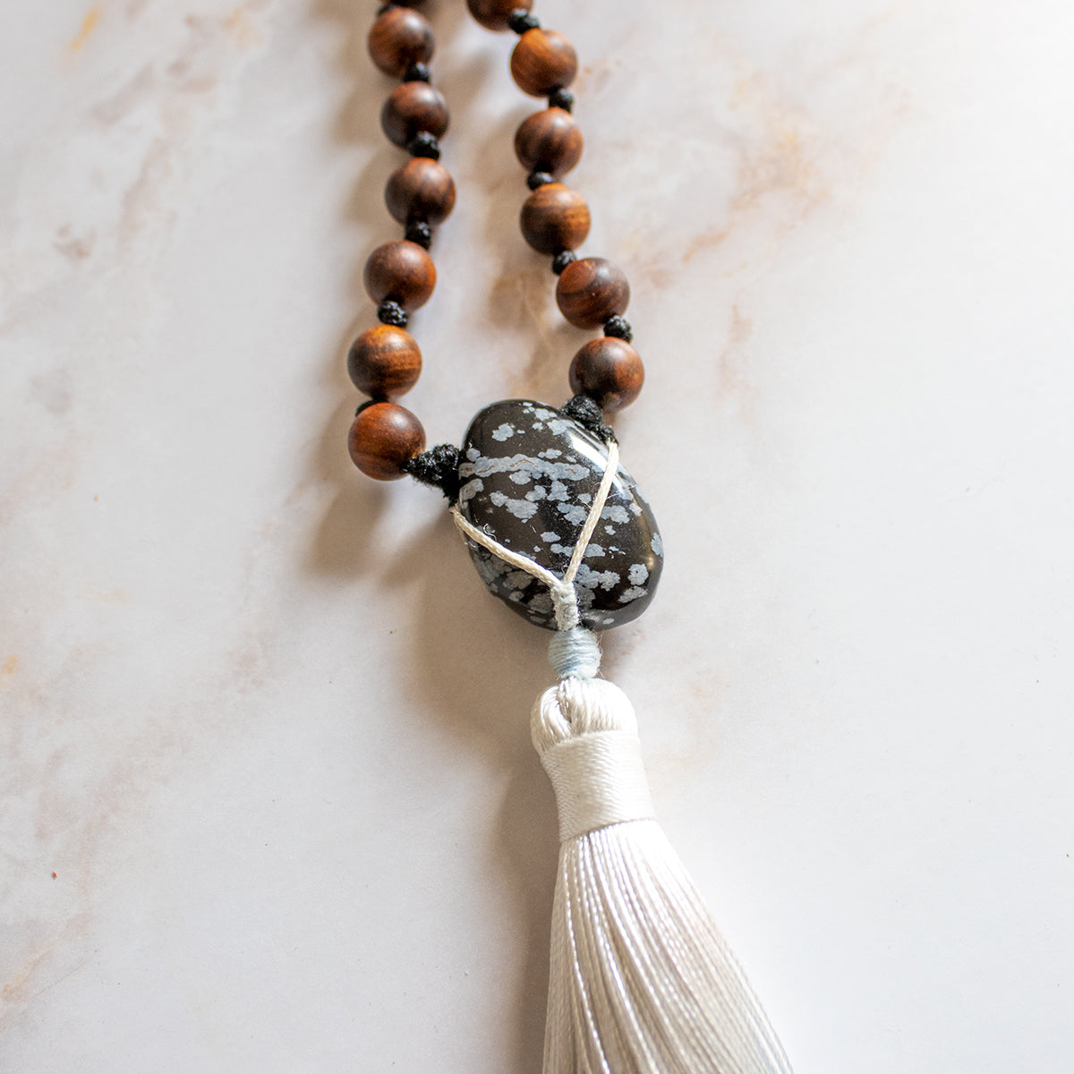 Collana mala legno con perline in legno scuro e pietra decorativa centrale con frangia bianca