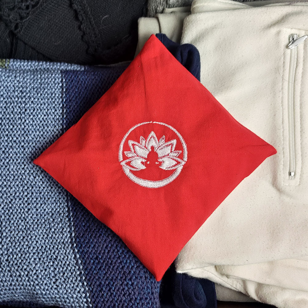 Cuscino rosso con simbolo del quarto chakra, ideale come profumatore ambiente quarto chakra per la casa.