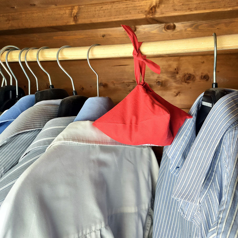 Profumatore ambiente quinto chakra in tessuto rosso appeso a una gruccia con camicie per una casa profumata