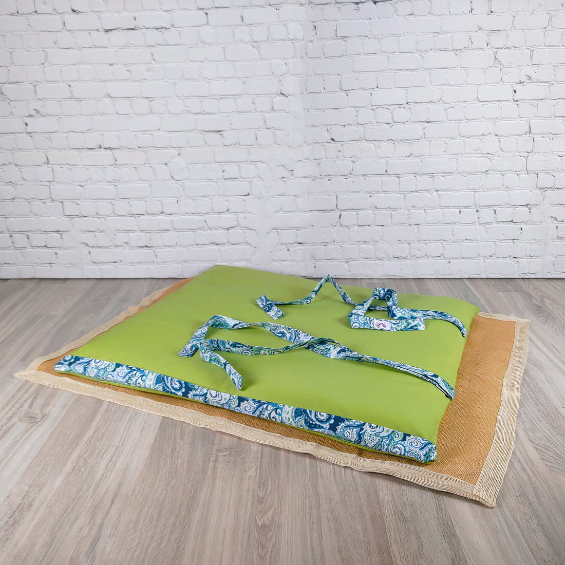 Stuoia da spiaggia verde con cinghie decorative azzurre, perfetta per il relax al mare