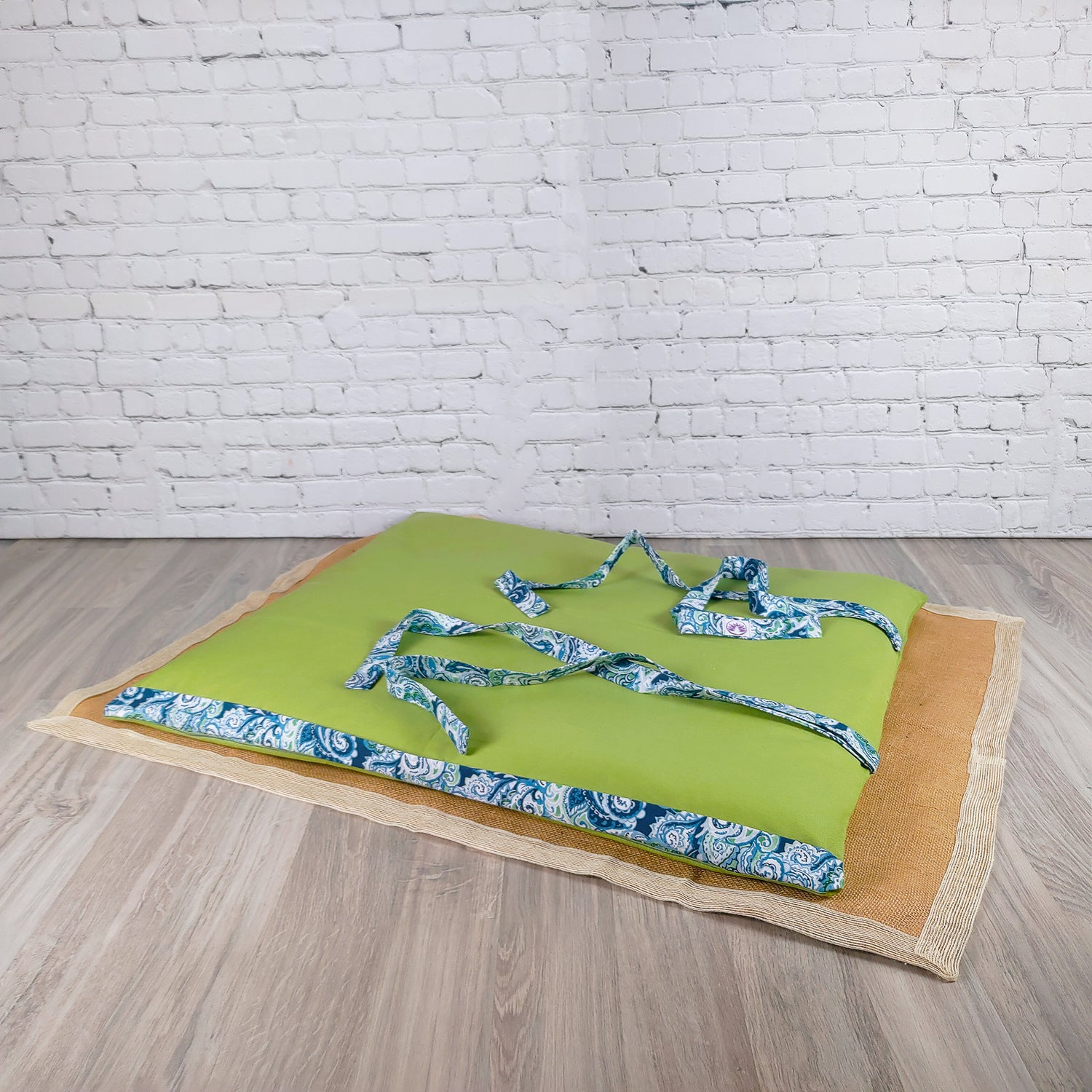 Stuoia da spiaggia verde con cinghie decorative azzurre, perfetta per il relax al mare