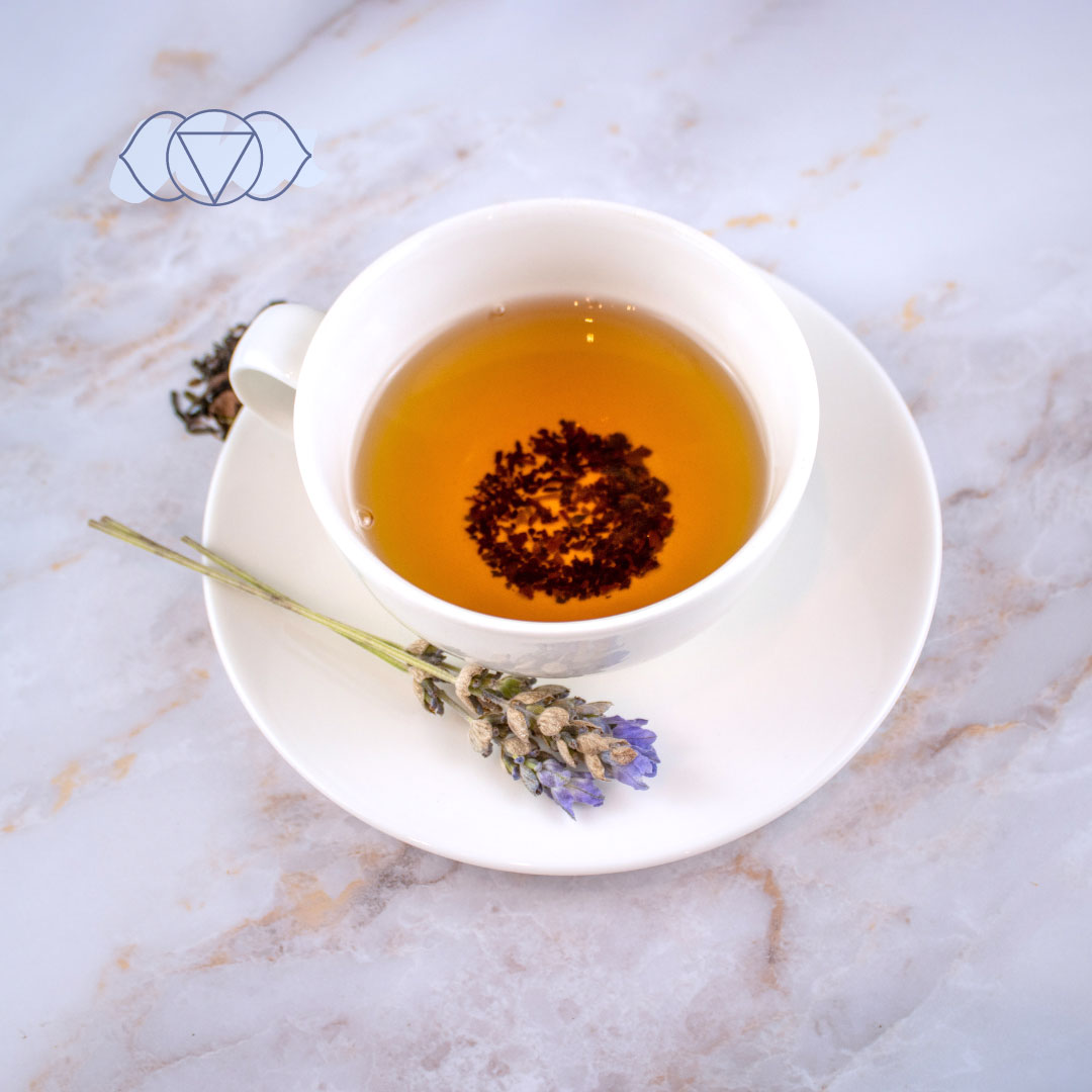 Tisana sesto chakra in tazza bianca con fiori di lavanda per un benessere olistico
