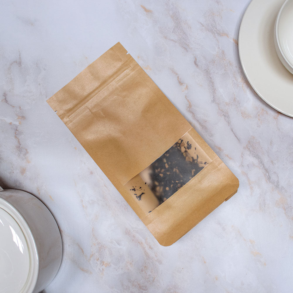 Confezione di Tisana Terzo Chakra in sacchetto di carta, ideale per un rilassante tè alle erbe