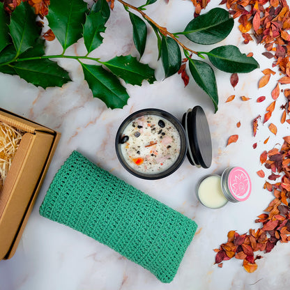 Confezioni regalo con box benessere artigianale, candele, e prodotti naturali su un tavolo decorato