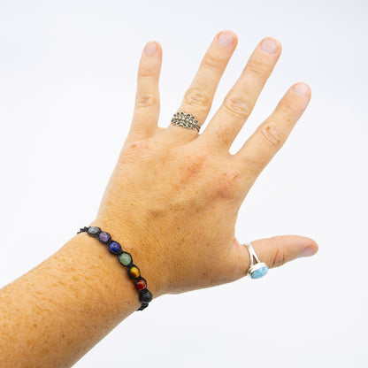 Bracciale chakra macramé con perline colorate indossato su una mano aperta
