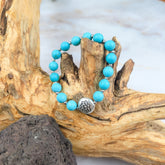 Bracciale loto turchese con perle azzurre e charm in metallo, elegante e spirituale