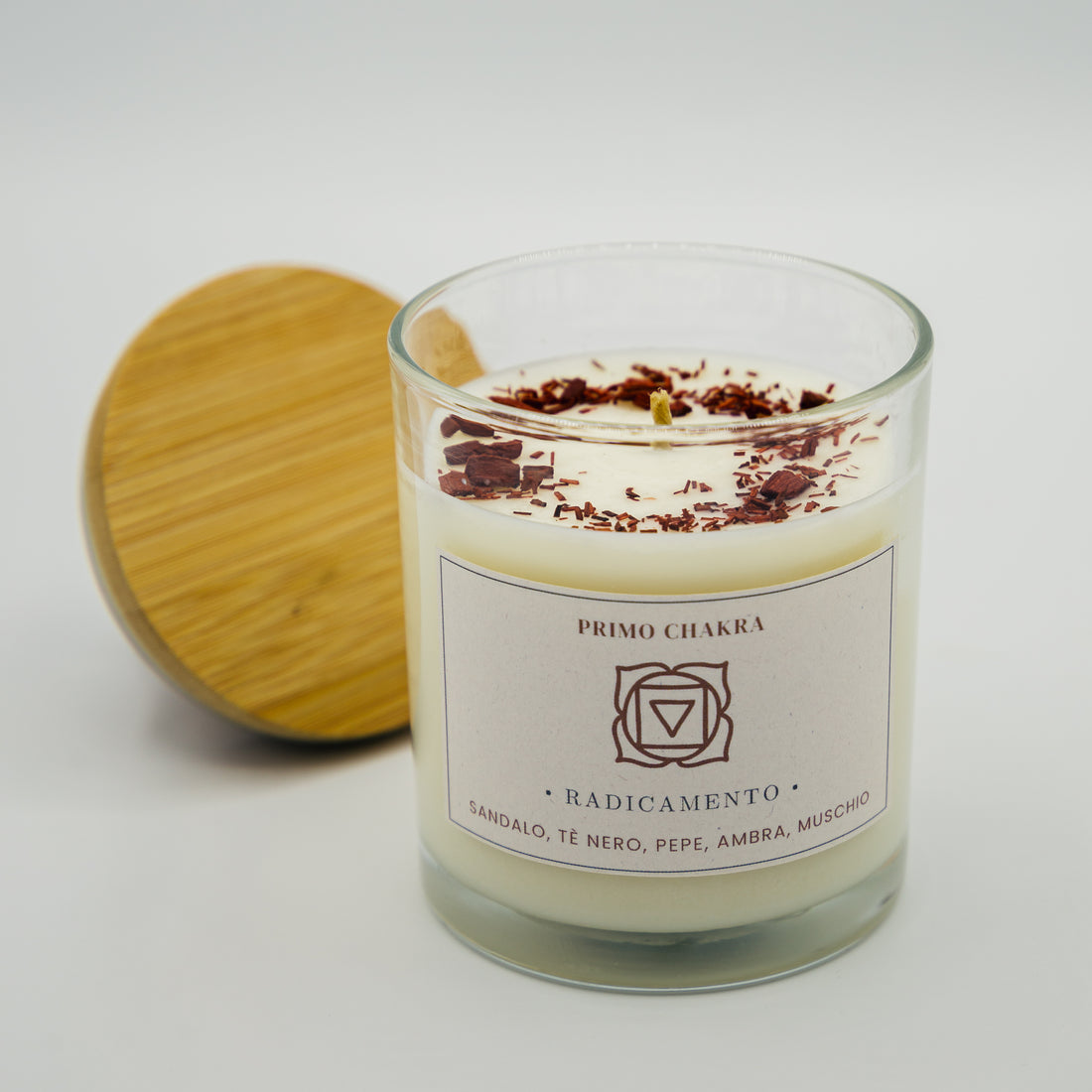 Candela radicamento primo chakra in vaso di vetro con coperchio in bambù e decorazioni naturali