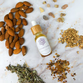 Olio per massaggi settimo chakra in bottiglia con ingredienti naturali sul piano di lavoro