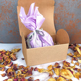 Confezione regalo in cartone con dettagli rosa, perfetta come box benessere corpo per un trattamento rilassante
