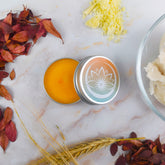 Burro labbra naturale in confezione con ingredienti naturali e sfondo di foglie autunnali