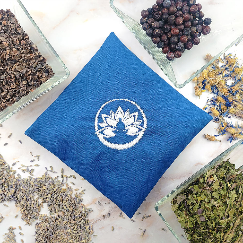 Set completo aromaterapia chakra con cuscino blu e erbe essenziali disposte attorno
