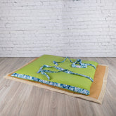 Stuoia da spiaggia verde con cinghie decorative azzurre, perfetta per il relax al mare